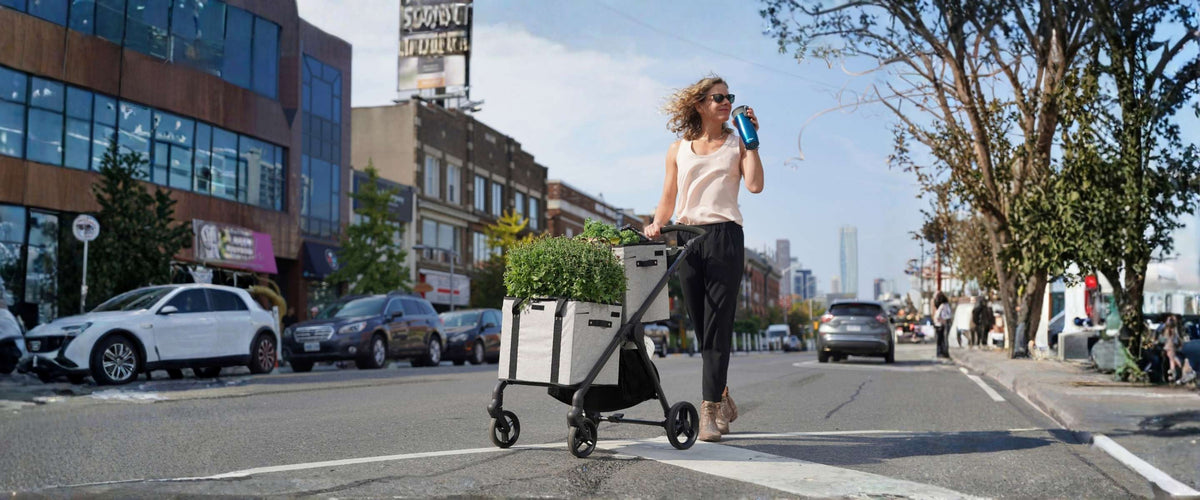 Fashionable woman walking naturally with foldable shopping cart in city