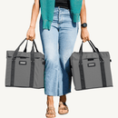 Person holding two gray VOOMcart easy to carry grocery bins with black handles on a white background